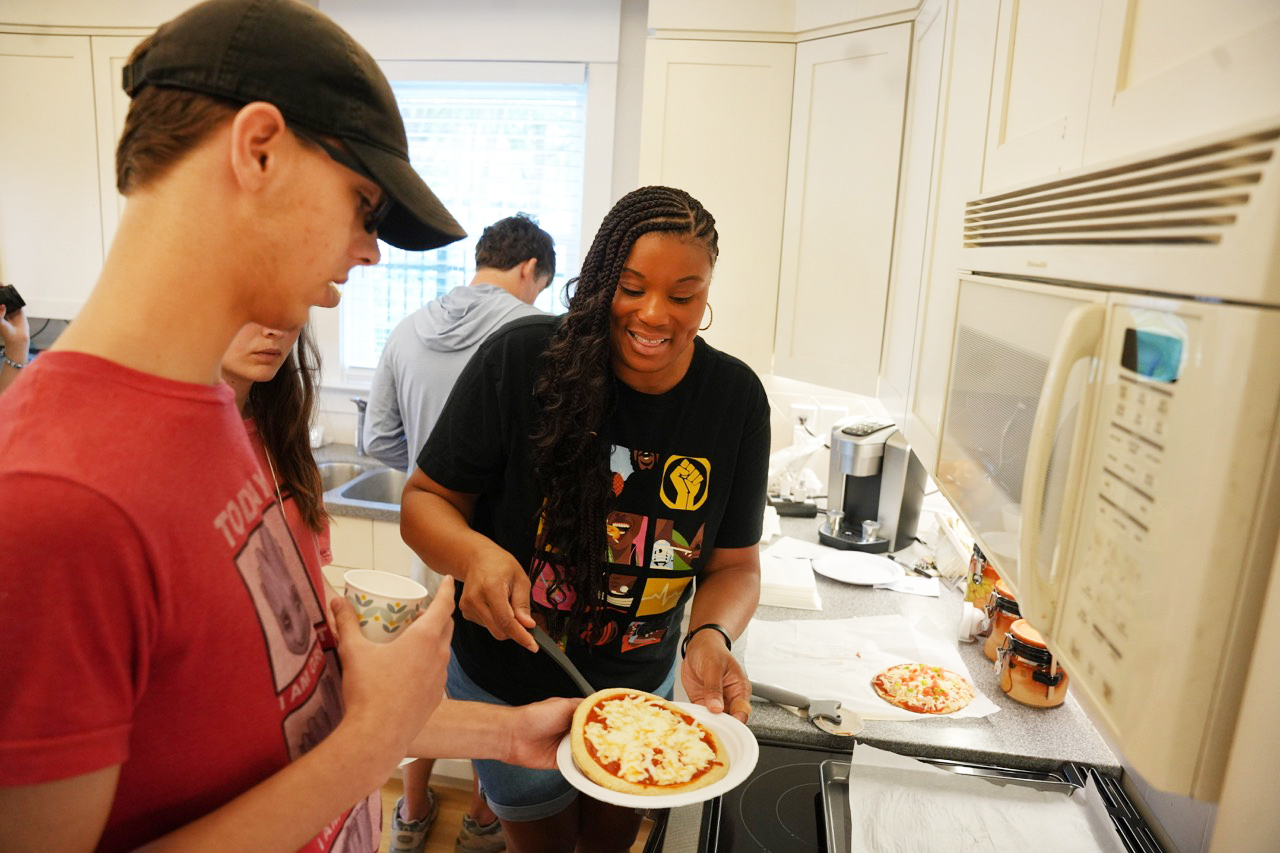 Sherri Burrell assists EXCEL student cooking pizza at the AWARE Home.